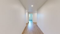 Located on Sepulveda Blvd in Los Angeles, this single-floor, 4-bedroom, 2-bathroom home offers a clean, modern aesthetic with a cohesive design throughout. Light wood vinyl flooring runs continuously across all rooms, complementing the crisp white walls and creating a bright, open atmosphere.

The layout includes a combined kitchen and living area, four bedrooms, two bathrooms, four closets, and a connecting hallway. Each bedroom features natural light through large windows with roller shades, offering views of the surrounding neighborhood. Several bedrooms include built-in sliding closets, providing practical storage. The primary bedroom is generously sized and benefits from a wide window that fills the room with natural light.

The hallway connects the rooms with a clean, linear flow, enhanced by recessed ceiling lighting. The two bathrooms are finished in a consistent modern style — one features a full tub-shower combo with white tile surround, a vanity with undermount sink, and a large mirror, while the second is equipped with accessibility grab bars, a vanity, and a toilet, reflecting thoughtful, inclusive design.

Throughout the home, the minimalist design aesthetic, neutral palette, and abundant natural light create a fresh, functional living environment well-suited to the Los Angeles lifestyle.
