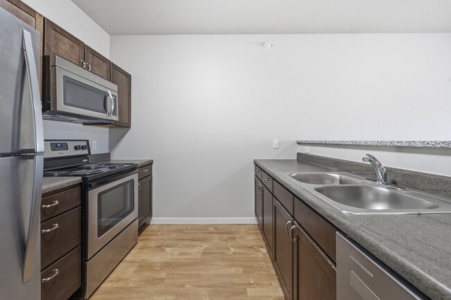 Step into the modern kitchen at North Highlands Apartments, featuring sleek stainless steel appliances, ample counter space, and contemporary cabinetry. Ideal for culinary enthusiasts and everyday living. Schedule your tour today! - North Highlands Apartments and Villas