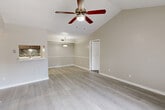 Located at 2305 Hayes Rd in Houston, TX, this well-appointed single-story home offers 2 bedrooms and 2 bathrooms with a functional, efficient layout. The open living and dining area makes a strong first impression with its vaulted ceilings, ceiling fan, and light wood-style flooring that flows throughout. A classic white fireplace serves as a focal point in the living room, which also features a sliding glass door that fills the space with natural light. The kitchen is thoughtfully designed in a galley style, featuring gray cabinetry, white countertops, a mosaic tile backsplash, black appliances, and a dedicated pantry for added storage. Both bedrooms are carpeted and equipped with ceiling fans; the generously sized primary bedroom includes a spacious walk-in closet with built-in shelving. The bathrooms are clean and functional, with a tiled tub-shower combination. Additional highlights include a dedicated laundry area, a hallway connecting the main living spaces, and a total of five closets throughout the home, ensuring excellent storage capacity. The neutral color palette and warm finishes create a welcoming ambiance throughout.
