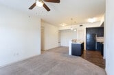 Located at 1509 Wayside Dr in Midland, Texas, this single-floor unit offers a practical and well-organized layout suited for comfortable everyday living. The kitchen is a standout feature, equipped with dark espresso cabinetry that extends to the ceiling, black appliances including a refrigerator, electric range, dishwasher, and microwave, and a white countertop peninsula with a double stainless steel sink. Pendant lighting illuminates the peninsula, which opens directly to the living area, creating a seamless flow between the two spaces. The kitchen and entry areas feature warm wood-look hard flooring, while the living room and bedrooms are finished with plush wall-to-wall carpeting. The living area is generously sized, with a ceiling fan, large windows fitted with blinds for light control, and a glass-panel door providing access to the exterior. The bedrooms are well-proportioned, carpeted spaces with windows that bring in natural light. The bathroom is clean and functional, featuring tile flooring, a tub-shower combination with white tile surround, a toilet, and a vanity with dark cabinetry and a large mirror. Throughout the unit, the neutral color palette and consistent finishes contribute to a cohesive and move-in-ready atmosphere.