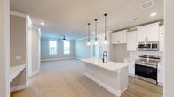 Located at 503 Town Madison Blvd in Madison, Alabama, this 2-bedroom, 2-bathroom single-story residence offers a well-designed open-concept layout with modern finishes throughout. The kitchen serves as a central hub of the home, featuring a large white island with a matte black faucet, crisp white shaker cabinetry extending to the ceiling, stainless steel appliances, and three pendant lights with glass shades that provide both task lighting and visual appeal. The kitchen flows seamlessly into the living area, which is finished with plush neutral carpeting, crown molding, and a ceiling fan.

Both bedrooms are generously proportioned, finished with soft carpet, crown molding, and ceiling fans. The spacious primary bedroom features French doors that open to an outdoor view, filling the room with natural light. The primary bathroom is well-appointed with a double-sink white vanity, matte black fixtures, a glass-enclosed tile shower, and light-toned tile flooring. The second bathroom mirrors this refined aesthetic with a soaking tub and dual-sink vanity. A dedicated walk-in closet provides ample built-in shelving and hanging storage. Neutral wall tones and consistent trim work create a cohesive, clean ambiance throughout.