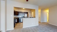 Located at Hamilton House in Mayfield Heights, Ohio, this single-floor residence presents a well-organized layout designed for comfortable everyday living. The open-concept living area is finished with plush carpeting and features a ceiling fan overhead, while a large sliding glass door spans nearly an entire wall, flooding the space with natural light and providing views of the surrounding exterior. Baseboard heating runs along the perimeter, supplemented by a wall-mounted air conditioning unit.

The kitchen is thoughtfully appointed with rich, dark-stained cabinetry featuring contemporary hardware, granite countertops, and a full suite of stainless steel appliances including a refrigerator, dishwasher, range, and microwave. Light wood-tone flooring grounds the kitchen space, which opens to the living area through a pass-through counter, creating a connected and functional flow between rooms.

The bathroom mirrors the kitchen's design aesthetic, featuring a dark vanity with granite countertops, an undermount sink, chrome fixtures, a mirrored medicine cabinet, and clean white tile work covering both the floor and walls, contributing to a bright and polished finish. Additional rooms visible in the floor plan offer flexible private spaces with carpeted flooring and easy access to the main living areas.