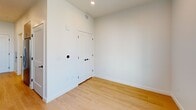This 290 square foot studio apartment in Salt Lake City offers a thoughtful blend of modern design and efficiency. The single-floor layout comprises a kitchen, bathroom, and open living area, making optimal use of the compact space. The kitchen is a standout feature, boasting a full suite of stainless steel appliances including a dishwasher, built-in microwave, and slide-in range. Light-colored cabinetry extends to the ceiling, maximizing storage, while a white quartz countertop and backsplash add a touch of elegance. The bathroom, while compact, is well-appointed with a modern toilet and likely includes a shower (not visible in images). Throughout the apartment, warm wood flooring creates a cohesive look and adds warmth to the predominantly white space. Recessed lighting in the kitchen and living area ensures bright, even illumination. A window in the living area offers natural light and city views, enhancing the sense of space. The apartment's clean lines, neutral color palette, and minimalist design create a contemporary, uncluttered ambiance perfect for urban living.