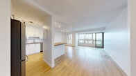 Located at 333 Riverside in Saint-Lambert, QC, this well-appointed 2-bedroom, 1-bathroom unit offers a bright and modern living experience. Light wood laminate flooring flows throughout the entire space, creating a warm and cohesive aesthetic.

The open-concept living and dining area is bathed in natural light, thanks to expansive floor-to-ceiling windows that frame scenic outdoor views. A private balcony extends from the living area, providing an excellent outdoor retreat. The kitchen is thoughtfully designed with crisp white cabinetry, wood-top counters, stainless steel appliances including a built-in oven, microwave, and refrigerator, and a central island that doubles as a breakfast bar — ideal for both cooking and entertaining.

The primary bedroom is generously sized and features its own dedicated closet, while the second bedroom also includes a built-in closet, both rooms benefiting from ample natural light. Three closets in total provide excellent storage throughout the unit. The bathroom showcases a modern vessel sink set on a natural wood vanity, complemented by white tile, a mirrored medicine cabinet, and clean chrome fixtures.

A welcoming hallway connects the rooms efficiently, completing this well-organized and contemporary living space in the heart of Saint-Lambert.
