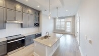 This contemporary 610-square-foot apartment in Franklin, TN, offers a harmonious blend of style and functionality. The open-concept layout maximizes space, seamlessly connecting the kitchen, living, and dining areas. The kitchen boasts sleek gray cabinetry, quartz countertops, and stainless steel appliances, complemented by a central island with a sink and pendant lighting. Large windows flood the space with natural light, while light wood-look flooring adds warmth throughout.

The 120-square-foot bedroom features plush carpeting, a ceiling fan, and a large window with blinds for privacy. The bathroom impresses with marble-look tile flooring, a spacious vanity, and a glass-enclosed shower. Modern fixtures and neutral color palettes create a cohesive design throughout the apartment.

Additional amenities include a closet for storage, energy-efficient lighting, and climate control for year-round comfort. The apartment's clean lines, high ceilings, and thoughtful design elements create an inviting and efficient living space, perfect for those seeking a stylish urban lifestyle in Franklin, Tennessee.