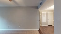 Located at 3000 Continental Colony Parkway in Atlanta, GA, this single-floor residence offers a practical and comfortable layout with neutral tones throughout. The living area features plush carpeting and a smooth transition to rich, dark hardwood-style flooring in the adjoining hallway, with vaulted ceiling details adding a sense of openness. Each bedroom is carpeted, painted in soft gray and taupe hues, and equipped with a ceiling fan for year-round comfort. Closet access is conveniently provided in each room. The kitchen is outfitted with white cabinetry featuring decorative molding, speckled countertops, a gas range, over-range ventilation hood, and a full-size refrigerator, complemented by a window that brings in natural light. Two bathrooms serve the residence — one featuring a tub-shower combination and the other a stand-alone shower — both finished with matching speckled countertops, white cabinetry, and dark hardwood-style flooring. A dedicated laundry room provides generous cabinet storage, a utility sink with matching countertops, and space for a full-size washer and dryer. The cohesive neutral palette and functional layout make this a well-appointed single-level home.