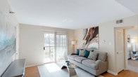 This well-appointed two-bedroom, two-bathroom single-floor residence offers a thoughtfully designed layout that balances comfort and functionality. The living room serves as the heart of the home, featuring warm hardwood-style flooring, neutral walls, and a sliding glass door that opens to a private balcony with outdoor views, allowing generous natural light to fill the space throughout the day.

Adjacent to the living area, a compact dining space provides an intimate setting illuminated by an overhead pendant light. The galley-style kitchen is efficiently organized with white cabinetry, granite-style countertops, a stainless steel sink, and a full suite of stainless steel appliances, including a refrigerator, range, and built-in microwave. A hallway off the kitchen leads to a laundry area.

Both bedrooms feature plush carpeting and windows that invite natural light. The primary bedroom includes a closet and connects to the hallway corridor. Each of the two full bathrooms is outfitted with a tub and shower combination, granite-topped vanity, and a large mirror with overhead lighting, providing a clean and functional finish throughout.