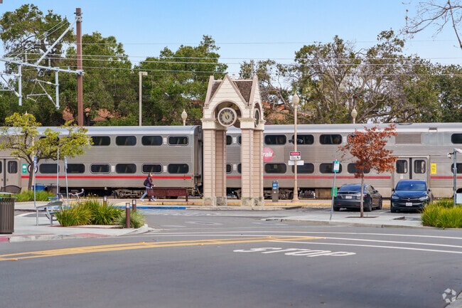 Caltrain departs from a bustling station near East Palo Alto.