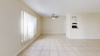 Located at 21227 US Highway 19 N in Clearwater, Florida, this single-story, 3-bedroom, 2-bathroom home offers a well-organized and functional layout. The open-plan living and dining area is a standout feature, finished with large light-toned ceramic tiles that extend throughout the main living spaces. Vertical blinds adorn the windows, and a ceiling fan provides comfort in the Florida climate. Sliding glass doors in the living area lead directly to the outdoors, allowing natural light to fill the room and providing easy access to the surrounding green space.

The kitchen features white cabinetry, dark granite-style countertops, a double stainless steel sink, and black appliances including a refrigerator and range. A pantry offers additional storage nearby.

The three bedrooms are carpeted and finished with warm neutral tones, each receiving natural light through windows with vertical blinds. The primary bedroom includes a closet with bifold doors. In total, the home features five closets, providing ample storage throughout.

Both bathrooms are tiled in warm tones and include a tub/shower combination, toilet, and vanity. A connecting hallway ties the layout together efficiently, making this home practical and comfortable for everyday living.