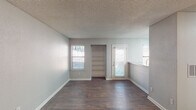 Located at 3271 Lynn Ridge Dr in Raleigh, NC, this single-floor home offers a practical and functional layout with consistent finishes throughout. The main living area is generously sized, featuring rich dark hardwood-style flooring, soft gray walls, a textured ceiling, and a built-in shelving unit that adds both character and storage. Natural light filters in through multiple windows fitted with horizontal blinds, creating a bright and welcoming atmosphere. A door from the living area provides convenient exterior access.

The galley-style kitchen is efficiently designed, offering white cabinetry with brushed hardware, light granite-style countertops, a stainless sink, and black appliances including an electric range and refrigerator. A window above the counter brings in additional natural light.

The bedroom features plush carpeting, a textured ceiling, and a window overlooking the outdoors. A dedicated area within the home houses an in-unit washer and dryer alongside a closet, providing excellent convenience. The bathroom includes a full tub-shower combination finished with clean white tile surround. Throughout the home, neutral tones and consistent finishes create a cohesive, move-in-ready environment suited for comfortable everyday living.