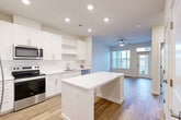 Located in La Plata, MD, this well-designed one-bedroom, one-bathroom residence offers a functional and modern single-floor layout. The open-concept living area seamlessly connects the kitchen, dining, and living spaces, creating an inviting and efficient flow. The kitchen is a standout feature, outfitted with crisp white shaker cabinetry, white quartz countertops, a central island, and stainless steel appliances including a range, over-the-range microwave, and dishwasher. Recessed lighting brightens the kitchen, while a ceiling fan adds comfort to the living area, which benefits from natural light through large windows and direct access to a private balcony. Hardwood-style flooring runs throughout the entire unit, lending a clean, cohesive aesthetic. The bedroom is a well-proportioned retreat with its own ceiling fan, a large window, and direct access to the full bathroom. The bathroom features a dual-sink white vanity, a soaking tub with shower, and a bright, neutral palette. Ample storage is provided through four closets, including a walk-in closet with wire shelving. The overall ambiance is modern, bright, and move-in ready.