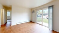 Located at 4705 N Breton Ct SE in Kentwood, Michigan, this single-floor unit offers a practical and well-organized layout with a clean, neutral aesthetic throughout. The living area is finished with warm hardwood-style flooring and features a wall-mounted air conditioning unit alongside baseboard heating for year-round climate control. Large sliding glass doors flood the space with natural light and provide direct views of the surrounding outdoor area, creating an open and airy feel. The kitchen is equipped with light gray cabinetry, a stainless steel sink, a gas range, and a dishwasher, all set on hardwood-style flooring that continues the cohesive look of the main living spaces. The bedrooms are carpeted for comfort and feature large windows that bring in ample natural light. One bedroom includes a sliding-door closet with a dedicated hanging rod, providing useful storage. The full bathroom is finished with hardwood-style flooring and includes a combined tub and shower, a toilet, and a vanity with wood-toned cabinetry. Throughout the unit, crisp white walls and neutral tones contribute to a bright, clean atmosphere that offers a versatile canvas for personalization.