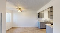 Located at 10453 Artesia Boulevard in Bellflower, CA, this single-floor, 2-bedroom, 2-bathroom home offers a practical and well-appointed layout. The open-concept living, dining, and kitchen area forms the heart of the home, finished with light wood-look flooring and crown molding throughout. A ceiling fan with light fixture adds both comfort and function to the main living space, which receives natural light through a window with outdoor greenery views.

The galley-style kitchen is a standout feature, equipped with gray shaker cabinetry, granite-look countertops, open shelving, a stainless steel double sink, and a stainless steel gas range. The kitchen flows seamlessly into the dining and living areas, making the space ideal for everyday living.

Both bedrooms are generously sized, with the primary bedroom featuring soft carpeting and neutral gray walls. The second bedroom also offers carpet flooring and a window with exterior views. Four closets are distributed throughout the home, providing ample storage.

The two bathrooms are cleanly appointed: one features a walk-in glass-enclosed shower with wood-look flooring, while the other includes a full soaking tub and shower combination. A hallway connects all areas of the home efficiently, completing this well-structured and move-in-ready residence.
