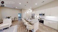 This thoughtfully designed 2-bedroom, 6-bathroom model home in Pittsboro, NC offers a well-appointed single-floor layout with modern finishes throughout. The open-concept kitchen serves as the heart of the home, showcasing white shaker cabinetry, stainless steel appliances, a subway tile backsplash, and a granite-topped island with seating for multiple guests — illuminated by elegant pendant lighting. Light-toned hardwood-style flooring flows through the main living areas, complementing the warm, neutral color palette. The living area is bright and inviting, with natural light filtering through large windows and access to a covered balcony with metal railing, offering views of the surrounding exterior. Both bedrooms feature plush carpeting, ceiling fans, and generous windows that bring in ample natural light. The primary bedroom includes an en-suite bathroom with a dual-sink vanity topped with granite counters and a glass-enclosed walk-in shower finished in crisp white tile. A dedicated laundry room with full-size washer and dryer hookups and built-in shelving adds everyday convenience. A closet provides additional storage. The overall ambiance is clean, contemporary, and comfortable — ideal for modern living in the heart of Chatham County.