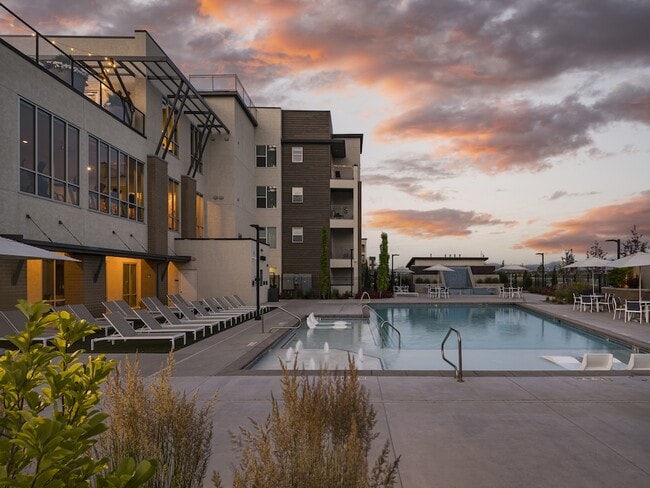 Piscina y bañera de hidromasaje al atardecer - Parc View Apartments & Townhomes