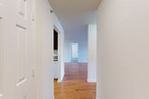 Located at 6333 Village Center Dr in Bealeton, VA, this 2-bedroom, 2-bathroom residence offers a practical and comfortable single-floor layout. The entrance opens into a bright hallway with warm hardwood flooring that flows throughout the main living areas. The combined dining and living room is generously proportioned, bathed in natural light, and features track lighting and clean white walls, creating an open, airy atmosphere. The kitchen is outfitted with rich dark-toned cabinetry, granite-style countertops, and white appliances including a refrigerator, electric range, and microwave, complemented by a dedicated pantry for added storage. Both bedrooms are carpeted and well-sized, with the primary bedroom offering ample space and access to a large walk-in closet with wire shelving systems. The second bedroom features a double-door closet. Two full bathrooms include tub-shower combinations with clean, bright finishes. A dedicated laundry room houses a full-size washer with overhead shelving. Additional highlights include three closets throughout, a private balcony, and a textured ceiling detail in select rooms. The overall ambiance is clean, neutral, and move-in ready.