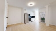 Located at 540 Bond Street in Bridgeport, CT, this thoughtfully designed one-bedroom, one-bathroom unit offers a clean, modern aesthetic throughout. Light hardwood flooring runs continuously across the entire space, creating a cohesive and airy feel.

The open-plan living and kitchen area is anchored by a well-appointed kitchen featuring white shaker cabinetry, a dark tile backsplash, stainless steel appliances including a full-size refrigerator and range, and ample counter space. A decorative column adds an architectural detail to the living area, which offers generous room for furnishings.

The bedroom is comfortably sized, bathed in natural light from two windows that frame outdoor views of the surrounding neighborhood. A wall-mounted HVAC unit provides climate control, and two closets with modern black hardware offer practical storage solutions.

The bathroom showcases contemporary finishes, including a floating green vanity with a white basin, black-framed mirror, matte black fixtures, and terrazzo-style floor tiles, lending a stylish, updated look.

Two additional closets provide extra storage throughout the unit. Clean white walls, modern flush-mount lighting, and consistent trim details contribute to the space's bright, minimalist character throughout.