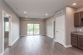 This well-designed single-floor unit offers a thoughtful layout that balances open communal areas with comfortable private spaces. The open-concept living and dining area is finished with durable light wood-tone flooring and neutral gray walls, creating a bright and versatile space. A sliding glass door leads to a private balcony, allowing natural light to pour in and providing outdoor views of surrounding greenery.

The kitchen is efficiently designed and features rich dark wood cabinetry, granite countertops, a mosaic tile backsplash, and a full suite of stainless steel appliances including a refrigerator, range, microwave, and dishwasher. An entry hallway with hard flooring connects the main living space to the rest of the unit.

Two generously sized bedrooms are finished with plush carpeting, ceiling fans, and multiple windows dressed with horizontal blinds, offering ample natural light and outdoor views. Each bedroom provides a quiet and comfortable retreat.

The unit includes two bathrooms, both finished with dark wood vanities, granite countertop sinks, and wood-tone tile flooring. One bathroom features a walk-in shower stall, while the other offers a vanity with a large mirror and convenient access to an adjoining bedroom. Together, these spaces combine modern finishes and functional design for comfortable everyday living.