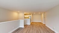 This single-floor residence provides a thoughtfully organized layout accommodating three bedrooms and three full bathrooms. The open-concept living and kitchen area serves as the heart of the home, featuring warm-toned laminate wood flooring, recessed lighting, and a neutral color palette that creates a bright, welcoming atmosphere. The kitchen is equipped with stainless steel appliances—including a refrigerator, range, and over-the-range microwave—complemented by white shaker-style cabinetry, light countertops, and a peninsula that connects the kitchen to the living space.

The bedrooms are carpeted for comfort, finished with soft neutral tones and clean white trim. The primary bedroom offers a generous footprint with direct access to a private bathroom. The bathrooms are cleanly designed; one features a glass-enclosed walk-in shower with white cabinetry, while another includes a full tub-shower combination. Each bathroom continues the light, modern aesthetic seen throughout the unit.

A dedicated laundry room accommodates a side-by-side washer and dryer. Three closets provide practical storage distributed across the floor plan. Overall, the space presents a clean, functional, and move-in-ready design.