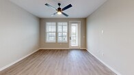 This well-appointed one-bedroom, one-bathroom unit in Oviedo, Florida offers a smart, efficient layout across a single floor. The open-concept living and kitchen area serves as the heart of the home, featuring light wood-look flooring, neutral wall tones, and a large sliding glass door and windows that flood the space with natural light while providing outdoor views. A ceiling fan adds both style and comfort to the living area.

The kitchen is a standout feature, showcasing white shaker-style cabinetry, a light gray tile backsplash, stainless steel appliances including a refrigerator, microwave, and range, and a generous center island with a white quartz countertop and undermount sink — ideal for both cooking and casual dining.

The bedroom is a comfortable retreat finished with plush carpet, a ceiling fan, and dual windows with blinds that frame neighborhood views. The full bathroom is clean and modern, featuring a glass-enclosed walk-in shower, white vanity cabinetry, and wood-look flooring. Conveniently accessible from the bathroom is a dedicated walk-in closet with built-in shelving, providing ample storage. The overall aesthetic is cohesive, bright, and move-in ready.