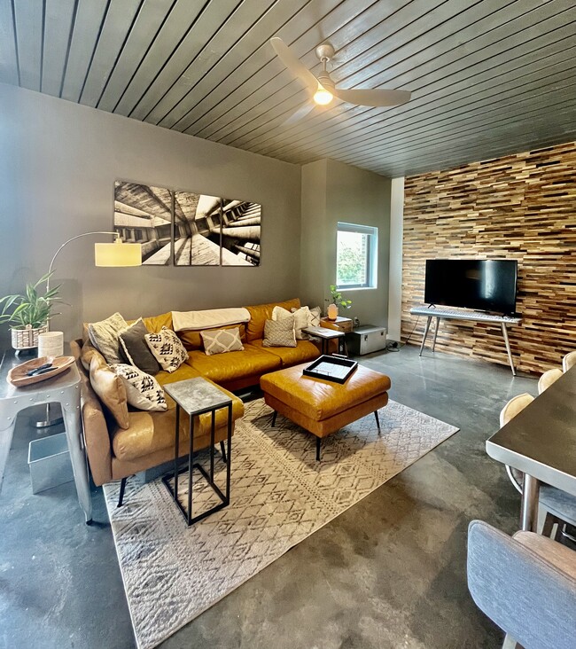 main living area with vegan sectional, 60 in smart TV, stained concrete floors - 620 Glen Iris Dr NE