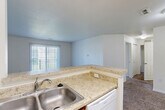 Located at 5280 Cedarshores Blvd in Flint, Michigan, this single-floor, 2-bedroom, 2-bathroom residence offers a well-organized layout designed for comfortable everyday living. The open-concept living and dining area is carpeted and bathed in natural light through sliding glass doors that lead to a private balcony. The kitchen features warm wood cabinetry, light granite-style countertops, a peninsula with a double-basin sink, white appliances including a gas range and refrigerator, and easy-care tile flooring. The primary bedroom is generously sized with plush carpeting and access to a spacious walk-in closet outfitted with wire shelving on both sides. The second bedroom is equally well-appointed with soft carpet and a large closet. Both bathrooms are clean and functional, featuring tub-shower combinations, vanities with storage cabinetry, and tile flooring. A dedicated laundry room adds everyday convenience. Throughout the residence, neutral tones and crisp white trim create a bright, move-in-ready atmosphere. With four closets total and a practical hallway connecting all rooms, storage and accessibility are key strengths of this thoughtfully designed home.