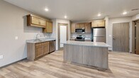 Located on Lovers Lane in Melrose, Minnesota, this two-bedroom, one-bathroom residence offers a well-designed single-floor layout with modern finishes and a practical, open feel. The combined kitchen and living area serves as the heart of the home, highlighted by light-toned luxury vinyl plank flooring, recessed lighting, and a sliding glass door that opens to a private balcony with outdoor views. The kitchen is thoughtfully equipped with warm wood cabinetry, granite-style countertops, a central island with additional storage, and a full suite of stainless steel appliances including a refrigerator, electric range, microwave, and dishwasher. The open layout allows the kitchen to flow seamlessly into the living area, creating an inviting and functional common space. Both bedrooms are carpeted for comfort, each featuring baseboard heating and natural light from windows with blinds. The primary bedroom offers a generous footprint with ample room for furnishings. The full bathroom includes a soaking tub and shower combination, a vanity with modern cabinetry, and tile-style flooring. A dedicated in-unit laundry room houses a full-size washer and dryer with wire shelving above. Two closets provide additional storage throughout the residence.