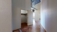 Located at 4 Fourth St E in downtown Saint Paul, MN, this two-bedroom, one-bathroom unit offers an industrial loft aesthetic with a range of distinctive architectural details. Polished terracotta tile flooring runs throughout the entire space, lending warmth and continuity to each room. The kitchen is a standout area, boasting soaring ceilings with an exposed, dark-painted ceiling that highlights industrial ductwork and pendant lighting. Light wood cabinetry, a central island with a dark countertop, black appliances, and multiple windows with sweeping city and river views complete the kitchen's character. The open layout flows naturally into a hallway that connects the bedrooms, bathroom, and a dedicated closet. The primary bedroom offers comfortable proportions and generous natural light, while the second bedroom features large windows with views of the surrounding Saint Paul skyline. The full bathroom includes a floating vanity with light wood cabinetry, a large mirror with bar lighting, and consistent terracotta tile flooring. Exposed ductwork, structural columns, and large windows with city views reinforce the building's urban, loft-inspired character throughout. Baseboard heating units are present in multiple rooms, ensuring year-round comfort in this architecturally rich downtown residence.