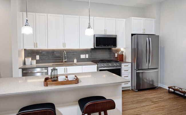 Classic Scheme kitchen with quartz countertops and island, stainless steel appliances, backsplash and hard surface flooring - Avalon Harrison