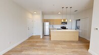 Located at 800 Everett Way in Perry, FL, this single-story 2-bedroom, 2-bathroom home offers a clean, modern aesthetic with a thoughtfully efficient layout. Light wood-tone flooring runs throughout the entire home, creating a cohesive and bright atmosphere that complements the neutral, warm-white walls and crisp white trim.

The open-concept living, dining, and kitchen area serves as the heart of the home. The kitchen is outfitted with warm bamboo-style cabinetry, a full suite of stainless steel appliances including a refrigerator, range, microwave, and dishwasher, and a large center island with a white quartz countertop illuminated by stylish pendant lighting. A dedicated in-unit laundry area is conveniently positioned just off the kitchen.

Both bedrooms are generously proportioned, featuring ceiling fans with light fixtures and windows that allow natural light to fill the space. The spacious primary bedroom includes a sliding double-panel closet. Three closets are distributed throughout the home, providing ample storage.

The two bathrooms maintain the home's consistent design language, featuring wood-toned vanities with white countertops and light flooring. A hallway connects the private areas of the home, keeping the layout organized and functional. The overall ambiance is modern, clean, and move-in ready.