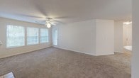 Located at 310 Chandler Rd in Greer, South Carolina, this single-story home offers a well-organized floor plan with comfortable living spaces throughout. The living room serves as the centerpiece of the home, featuring plush carpeting, a ceiling fan, and a tile-surround fireplace with a classic white mantel — an inviting focal point for the space. A raised pass-through counter connects the living area to the kitchen, which is equipped with a range and ample cabinetry, creating a practical and open feel. An adjacent dining or flex area provides additional living space with large windows that allow generous natural light to fill the room, along with a ceiling fan and access to an exterior door. The bedrooms are carpeted and equipped with ceiling fans for year-round comfort. Multiple bedrooms include walk-in or reach-in closets with built-in shelving, offering practical storage solutions. The home includes two full bathrooms, each featuring a tiled tub-shower combination, vanity with light wood cabinetry, and tile flooring. Textured ceilings are consistent throughout the home, contributing to its classic residential character. Overall, this home presents a clean, functional layout well-suited for comfortable everyday living.