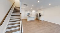 Located at 432 Lettie Ln in Rolesville, NC, this two-story home offers a well-designed layout across two floors. The main level features an open-concept kitchen and living area with light hardwood-style flooring, recessed lighting, and a clean, bright aesthetic. The kitchen is equipped with stainless steel appliances — including a refrigerator, range, and microwave — white shaker-style cabinetry, a tile backsplash, and a central island with a sink, providing ample prep and storage space. An attached garage with an automatic opener completes the ground floor. Upstairs, the home includes three bedrooms and three full bathrooms. The generously sized primary bedroom features plush carpeting, dual windows for natural light, and access to a private en-suite bathroom with a tiled walk-in shower, white vanity, and brushed gold fixtures. Additional bedrooms are carpeted and well-proportioned, with closet access. A walk-in closet with wire shelving provides organized storage. The dedicated upstairs laundry room includes a washer and wire shelf storage. Throughout, the home maintains a neutral, modern palette that offers a clean and move-in-ready feel.