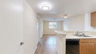 Located at 2301 NW 119th St in Miami, FL, this one-bedroom, one-bathroom unit offers a practical and well-organized layout across a single floor. Light wood-style flooring runs throughout the main living areas and bedroom, creating a cohesive and clean aesthetic.

The kitchen is designed for functionality, featuring warm-toned wood cabinetry, light countertops, a stainless steel sink, and black appliances including a refrigerator and electric range. A peninsula-style breakfast bar separates the kitchen from the living area, providing additional counter space and a natural flow between the two zones. Overhead flush-mount lighting keeps the kitchen bright and well-illuminated.

The living area is open and straightforward, benefiting from the connected kitchen layout and easy access to the front entry door. The bedroom is a cozy, well-proportioned space finished with the same light flooring, neutral beige walls, a ceiling fan with lighting, and a window fitted with blinds that allows natural light to filter in. A dedicated closet offers convenient storage within the unit.

The bathroom includes a full tub and shower combination with white tile surround, stainless steel grab bars for safety, and clean, minimal finishes. Textured ceilings are present in several rooms, adding a subtle design detail throughout the space.