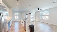 Located at 34 Ramsey Branch Rd in Freeport, FL, this well-appointed single-floor residence offers 2 bedrooms and 2 bathrooms thoughtfully arranged for comfortable everyday living. The open-concept kitchen and living area serves as the heart of the home, featuring a central island topped with granite countertops, a deep undermount sink with a matte black faucet, and stylish pendant lighting overhead. White shaker cabinetry, a subway tile backsplash, stainless steel appliances, and light wood-tone flooring give the kitchen a clean, contemporary aesthetic. The living area benefits from abundant natural light streaming through multiple windows, with a ceiling fan adding both function and style. A glass door opens to an outdoor area, seamlessly connecting interior and exterior spaces. Both bedrooms are carpeted and feature large windows that invite natural light and outdoor views. The primary bedroom includes its own closet, and the home boasts four closets in total, ensuring ample storage throughout. The bathrooms are finished in crisp white with wood-look flooring and tiled tub surrounds. A dedicated laundry area and a bright, clean hallway with recessed lighting complete this move-in-ready residence.