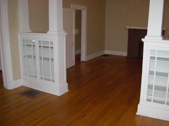 Living room and dining room (or den) separated by built-in bookcases. - 2024 Evelyn Ave
