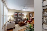 Located at 14698 Briar Forest Drive in Houston, TX, this well-appointed one-bedroom, two-bathroom residence offers a thoughtfully designed single-floor layout that maximizes every square foot. The open-concept living, dining, and kitchen area serves as the heart of the home, with warm hardwood-style flooring flowing throughout. The living room features large windows that invite natural light, complemented by a ceiling fan and crown molding. The kitchen is equipped with dark espresso cabinetry, stainless steel appliances including a refrigerator, range, and microwave, white countertops, a tile backsplash, and track lighting overhead. A dedicated dining area with its own track lighting provides an intimate setting for meals. The primary bedroom offers a comfortable retreat with plush carpeting, a ceiling fan, and direct sightlines to the kitchen. Two full bathrooms serve the residence — one featuring a soaking tub, a separate glass-enclosed shower, and large-format gray tile. Additional conveniences include a pantry, multiple closets, a utility room, and an in-unit laundry area, ensuring ample storage and functionality throughout.
