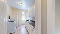 This 520 square foot apartment in Fair Lawn, NJ offers efficient single-floor living with two bedrooms and one bathroom. The space is characterized by its gleaming hardwood floors throughout, providing a warm and inviting atmosphere. The primary bedroom is notably spacious at 190 square feet, offering ample room for comfortable living.

The bathroom has been updated with modern fixtures, featuring a clean white palette accented by a sleek black tile border. It includes a combination tub and shower, along with a single vanity sink. Natural light filters in through a window, enhancing the bright, airy feel.

The kitchen, while compact, is efficiently designed with white cabinetry, providing ample storage. It's equipped with essential appliances including a gas stove and refrigerator. The dark countertops contrast nicely with the light cabinetry, and a window above the sink allows natural light to illuminate the space.

Both bedrooms benefit from large windows that flood the rooms with natural light, creating a sense of openness. The apartment's neutral wall color throughout provides a blank canvas for personal decor preferences. Baseboard heating units are visible in some rooms, ensuring comfort year-round.

The layout includes two hallways for easy navigation between rooms, contributing to the apartment's efficient use of space. Overall, this apartment offers a cozy yet functional living space in a convenient Fair Lawn location.