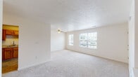 Located at 301 Friendship Ave in Hallam, Pennsylvania, this single-floor unit offers a well-organized layout designed for comfortable everyday living. The spacious living area is finished with plush wall-to-wall carpeting, neutral-toned walls, and a textured ceiling with a ceiling fan. Large multi-pane windows invite abundant natural light and provide views of the surrounding neighborhood, creating an open and airy atmosphere. The kitchen is fully equipped with warm oak cabinetry, ample counter space, and white appliances including a gas range, built-in microwave, refrigerator, and dishwasher. Stone-look tile flooring anchors the kitchen and extends into the bathrooms, offering both durability and a cohesive aesthetic. Multiple bedrooms feature soft carpeting and generously sized windows that continue the home's bright, welcoming character. Closet access is conveniently integrated into the bedroom areas. The bathrooms are cleanly finished with tile flooring, a wood-tone vanity, and grab bars for added accessibility, while one bathroom includes a shower-tub combination. The overall design emphasizes practicality and comfort, with a neutral palette throughout that makes the space easy to personalize.