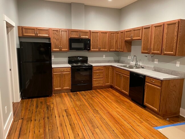 New kitchen cabinets, appliances and original refinished floors. Main room looking south. - 204 E Broadway Ave