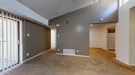 Located at 3410 Wildewood Dr, Unit 148 in San Angelo, TX, this single-floor residence offers a functional and straightforward layout. The main living area features warm beige carpeting, textured ceilings, and earthy taupe-toned walls, creating a neutral and versatile atmosphere. Ceiling fans are present in multiple rooms, providing efficient air circulation throughout the unit. HVAC vents are strategically placed along the walls and floors for consistent climate control.

The bedrooms are carpeted and bright, benefiting from natural light through blinded windows. Each room provides a clean, open canvas with white walls and ample wall space. One bedroom features a sliding closet door, offering convenient storage.

The bathroom is well-appointed with a wide vanity countertop, dual sinks, gold-tone hardware, and generous under-counter cabinet storage. The toilet area is separated for added privacy, and tile flooring runs throughout the bathroom, contrasting with the carpeted living spaces. A narrow window allows natural light into both the vanity and toilet areas.

Overall, the unit presents a clean, neutral interior with practical finishes, making it a versatile space suitable for a range of furnishing styles and needs.
