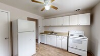 Located at 720 Melany Ln in Colorado Springs, Colorado, this single-story home offers a practical and well-organized floor plan designed for comfortable everyday living. The kitchen serves as a central functional space, outfitted with white cabinetry extending to the ceiling for ample storage, a double-basin sink, a full suite of white appliances including a refrigerator, dishwasher, and electric range, and warm-toned laminate countertops. A ceiling fan with built-in light provides ventilation and illumination throughout the kitchen. The light wood-style flooring in the kitchen carries a clean, cohesive aesthetic. Additional rooms feature plush carpeting, ceiling fans, and windows that allow natural light to filter in, creating a comfortable and airy feel. One room showcases wood-style flooring alongside a window-mounted air conditioning unit, offering flexible climate control. The bathroom includes a full tub-shower combination with white tile surround, maintaining a simple and functional design. The overall layout, as seen in the dollhouse view, is compact yet thoughtfully arranged, with clearly defined spaces flowing from the kitchen into the living and sleeping areas. This home provides a no-fuss, move-in-ready environment suited for a variety of lifestyles in the Colorado Springs area.