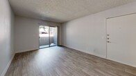 Located at 8600 Starboard Dr in Las Vegas, NV, this well-appointed 2-bedroom, 2-bathroom residence offers a practical and comfortable single-floor layout. Light-toned wood-look flooring flows consistently throughout the living areas and bedrooms, creating a cohesive and clean aesthetic. The open living room is bright and airy, featuring a textured ceiling, neutral walls, and a sliding glass door that leads to a private patio with outdoor views of surrounding greenery. The adjacent dining area connects seamlessly to the kitchen, which is thoughtfully designed with white shaker-style cabinetry, granite-look countertops, a mosaic tile backsplash, and stainless steel appliances including a refrigerator, dishwasher, and electric range. Both bedrooms offer comfortable proportions with natural light from windows overlooking the exterior. The primary bedroom is generously sized and connects to its own bathroom. The bathrooms feature wood-look flooring, granite-topped vanities with undermount sinks, and shower stalls with clean white tile surrounds. A dedicated in-unit laundry area houses a washer and water heater, adding everyday convenience. A hallway with closet storage completes this efficiently designed residence.