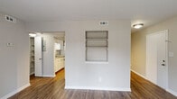 Located at 903 Kensington Dr in Cary, NC, this single-floor home offers five bedrooms and one bathroom across a well-organized layout. The living area features durable hardwood-style flooring and a built-in wall shelving unit, adding a practical touch to the open space. A connecting hallway leads seamlessly to the kitchen and bedroom wing.

The kitchen is equipped with white cabinetry, granite-style countertops, a double sink, dishwasher, and a full-size refrigerator, all complemented by hardwood-style flooring and a chair-rail accent along the walls.

The five bedrooms are carpeted and finished in neutral tones, providing a comfortable and versatile atmosphere. Several bedrooms feature bifold-door closets with built-in rods and shelving, while at least one bedroom benefits from a large window offering natural light and outdoor views. One room is outfitted with track lighting, offering added flexibility. The primary bedroom provides a generous amount of space with its own closet access.

The bathroom includes a full soaking tub with white tile surround. Throughout the home, clean white trim, neutral wall tones, and consistent finishes create a cohesive and move-in-ready environment suitable for a variety of living arrangements.