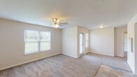 Located at 400 Liberty Landing Circle in Farmington, Missouri, this single-floor unit offers a thoughtfully designed open-concept layout that seamlessly connects the kitchen, dining, and living areas. The kitchen is a standout feature, showcasing rich dark-wood cabinetry, light-toned countertops, a center island with pendant lighting, and a full suite of black appliances including a range, dishwasher, microwave, and refrigerator. Stone-look tile flooring anchors the kitchen and entry areas, adding a durable and attractive touch. The open living room is generously proportioned, featuring soft wall-to-wall carpeting, a ceiling fan with light fixture, and multiple windows dressed with blinds that invite ample natural light and outdoor views. A glass-paneled door provides additional access and light to the living space. The bedroom continues the comfortable carpeted flooring, includes a ceiling fan, and benefits from a well-positioned window for natural illumination. The bathroom is outfitted with a clean, full-size tub and shower combination featuring chrome fixtures. The unit's neutral color palette and open floor plan create a bright, welcoming ambiance throughout.