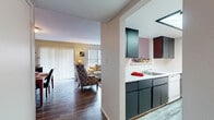 This single-story unit in Memphis, Tennessee offers a practical and comfortable layout across a compact but well-utilized footprint. The living room serves as the heart of the home, featuring a striking dark-tiled fireplace as a focal point, wood-look flooring, and large windows with vertical blinds that invite natural light. A pass-through opening connects the living area to the kitchen, enhancing the open feel between spaces.

The galley-style kitchen is efficiently designed with dark cabinetry contrasting against white countertops and white appliances, including a range and refrigerator. A window at the end of the kitchen provides additional natural light. Adjacent to the living area, the dedicated dining space accommodates a full-sized table and is finished with wood-look flooring.

Both bedrooms feature plush carpet flooring and are served by a hallway connecting the private areas of the unit. The primary bedroom offers two closets and windows on multiple walls, lending a bright and airy feel. The shared full bathroom includes a dark vanity with a white countertop, wood-look flooring, and a shower-tub combination.