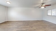 Located at 227 S Armenia Ave in Tampa, FL, this single-story, 2-bedroom, 1-bathroom unit offers a thoughtfully arranged layout that makes efficient use of its compact footprint. Consistent wood-look luxury vinyl flooring runs throughout the main living areas and bedrooms, creating a cohesive, clean aesthetic complemented by crisp white walls and bright white baseboards.

The combined living and dining area is an open, well-lit space featuring a ceiling fan with light fixture and windows fitted with blinds that allow natural light to filter in. The kitchen transitions directly from this area and is equipped with white cabinetry, dark countertops, stainless steel appliances including a refrigerator and electric range, an overhead exhaust hood, and tile flooring.

Both bedrooms continue the wood-look flooring and include ceiling fans. The primary bedroom provides a comfortable footprint with a closet accessible through the hallway. The second bedroom features a window with outdoor views and ample natural light.

The bathroom is finished with large-format travertine-style wall tiles surrounding a soaking tub and shower combination, with a built-in niche for added functionality. A dedicated laundry area and connecting hallway complete the unit's practical layout.