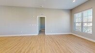 This well-appointed one-bedroom, two-bathroom residence in Mission, Kansas offers a thoughtfully designed single-floor layout with modern finishes throughout. The open-concept living, dining, and kitchen area forms the heart of the home, featuring light wood-tone luxury vinyl flooring, recessed lighting, and neutral gray walls that create a bright and airy atmosphere. Multiple windows flood the living space with natural light, and a door leads directly to a private balcony. The kitchen is outfitted with crisp white shaker cabinetry, a subway tile backsplash, granite countertops, stainless steel appliances including a dishwasher, microwave, range, and refrigerator, and a central island that provides additional prep and seating space. The spacious primary bedroom is carpeted for comfort and includes a ceiling fan, a generous window with outdoor views, and access to a walk-in closet. The en-suite primary bathroom features a dual-sink vanity with granite countertops, white cabinetry, large mirrors, and wood-tone flooring. A second full bathroom includes a pedestal sink and matching flooring. A dedicated laundry room houses a full-size washer and dryer with overhead shelving for added storage. Two closets and a utility room round out the functional layout of this modern residence.