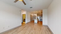 Located in Orlando, FL, this well-designed one-bedroom, one-bathroom unit offers a thoughtful layout across a single floor. The open-concept kitchen and living area serves as the heart of the space, anchored by a substantial granite-topped island with pendant lighting above. The kitchen is outfitted with grey shaker-style cabinetry, open shelving, stainless steel appliances including a refrigerator with ice maker, range, microwave, and dishwasher, all set against a clean tile backsplash. Light wood-look flooring runs consistently throughout, lending warmth and continuity to the space.

The living area is bright and airy, featuring a ceiling fan and multiple windows dressed with horizontal blinds that invite natural light while maintaining privacy. The bedroom is a comfortable, well-proportioned retreat with large windows offering outdoor greenery views, a ceiling fan, and the same wood-look flooring for a cohesive feel. A dedicated closet provides convenient storage.

The bathroom is elegantly finished with marble-look tile flooring and wall surrounds in the tub-shower combination, complemented by a grey vanity with a granite countertop. Clean white walls throughout the unit create a bright, neutral palette that enhances the sense of openness. The space also includes a dedicated entry closet, adding practical functionality.