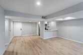 Located in the vibrant Los Feliz neighborhood of Los Angeles, this single-floor unit at 1840 N Kenmore Ave offers a clean, modern aesthetic with thoughtfully updated finishes throughout. The open-concept living and dining area is anchored by light wood-tone flooring that flows seamlessly across the space, complemented by soft gray walls and recessed lighting that create a bright, welcoming ambiance. A tray ceiling detail adds architectural interest to the main living area.

The kitchen features white shaker cabinetry, marble-look quartz countertops, a classic subway tile backsplash, and stainless steel appliances — a functional and stylish space that opens toward the main living area via a convenient pass-through. The bedrooms are generously proportioned, each with the same warm wood flooring, soft neutral walls, and recessed lighting. One bedroom includes a walk-in closet with built-in shelving, while another features floor-to-ceiling sliding glass doors with vertical blinds that invite abundant natural light and provide outdoor views.

The bathroom is well-appointed with a white vanity, marble-look countertop, wood flooring, and a full tub-shower combination enclosed by sleek sliding glass doors with chrome hardware. The overall design is cohesive, modern, and move-in ready.