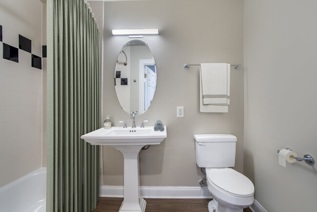 Renovated Package II bathroom with white countertops and hard surface flooring - Avalon at Gallery Place